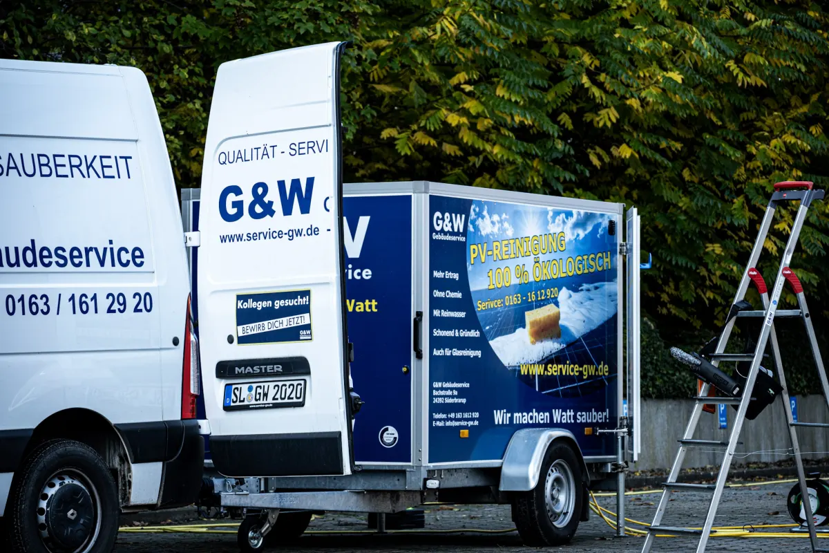 Ein G&W-Transporter mit Anhänger, auf dem Anhänger steht PV-Reinigung, 100 % ökologisch.